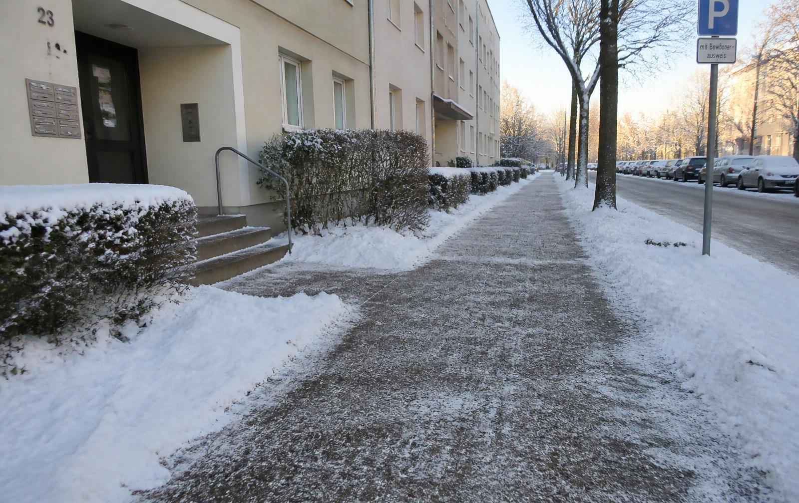 Frei geräumter und gestreuter Gehweg vor einem Wohnhaus an einem Wintermorgen in Stuttgart